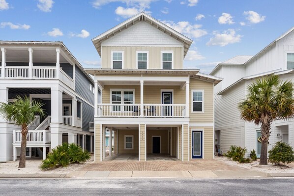 A two-story residential building with a balcony, a front porch, and a garage. - Seaside Cottage: Community Pool, Hot Tub and Gated. Sleeps 11. Dog Friendly! (Navarre)