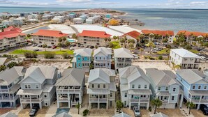 A coastal residential area with beachfront properties, including houses with balconies and a beachside promenade. - Seaside Cottage: Community Pool, Hot Tub and Gated. Sleeps 11. Dog Friendly! (Navarre)