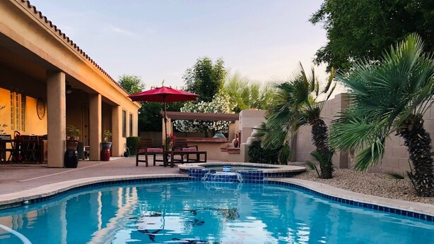 A swimming pool with a patio area, outdoor seating, and palm trees. - Private Casita w/ New Full Kitchen, Private Pool, Gated Community (Goodyear)