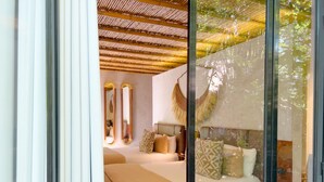 Un dormitorio moderno con una cama grande, un espacio para sentarse y un techo con diseño tejido.