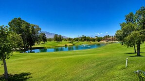 A golf course with a pond, trees, and mountains in the background. - Mirage Oasis | 3BR Retreat with Private Pool & Jaw-Dropping Views – a Greenday property! (Rancho Mirage)