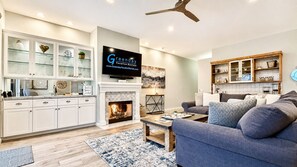 A modern living room with a fireplace, television, and a sofa.