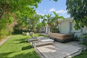 Un jardin avec une pelouse, une table de billard et du mobilier d’extérieur.