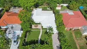 Vue aérienne d’un quartier résidentiel avec des maisons, une piscine et une pelouse bien entretenue.