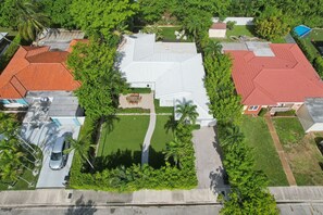 An aerial view of a residential area with houses, a swimming pool, and a well-maintained lawn. - Luxury Island Villa Isla~ New & Remodeled Paradise (North Bay Village)