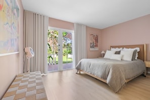 A bedroom with a large bed, a door leading to a balcony, and a painting on the wall. - Luxury Island Villa Isla~ New & Remodeled Paradise (North Bay Village)