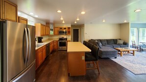Una cocina moderna con un refrigerador de acero inoxidable, armarios de madera y una isla central.