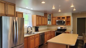 Una cocina moderna con electrodomésticos de acero inoxidable, armarios de madera y una isla central.
