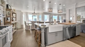 A spacious kitchen with a large island, built-in appliances, and ample natural light. - Luxury Beachfront, Private Patio, Fire Pit, BBQ (Carlsbad)