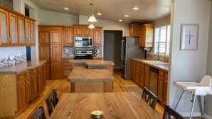 A spacious kitchen with wooden cabinets, a central island, and modern appliances. - Relaxing Rural Family Home with a great outdoor experience (Woodward)