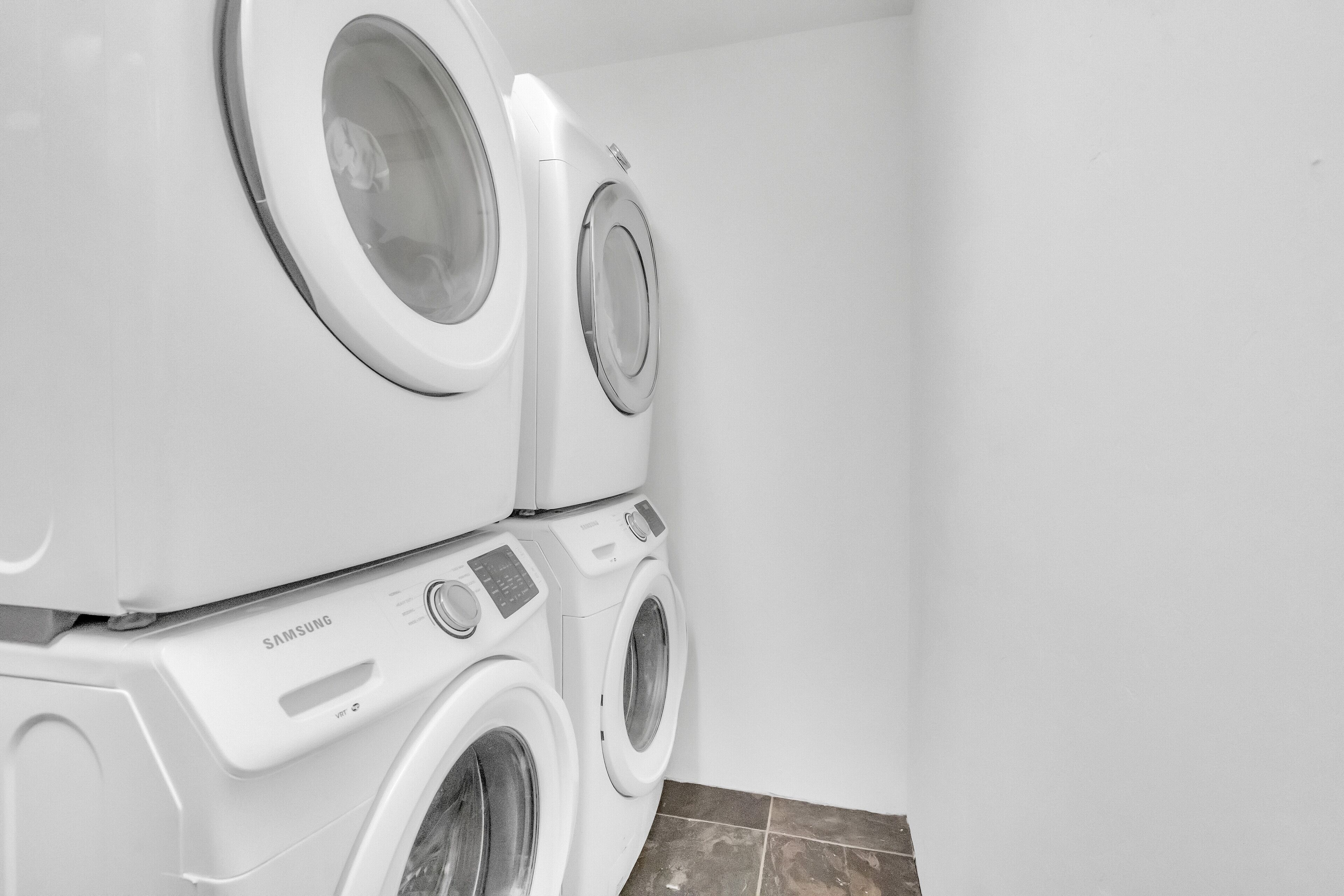 Una lavadora y secadora apiladas en un cuarto de lavado.