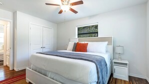 A bedroom with a bed, a nightstand, a ceiling fan, a window with blinds, and a door. - "Stadium Oasis" - A quick walk to the stadiums! (Arlington)
