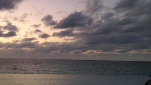 Une plage avec vue sur l’océan et un ciel nuageux.