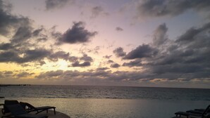 Une scène de plage avec des chaises longues et une vue sur l’océan.