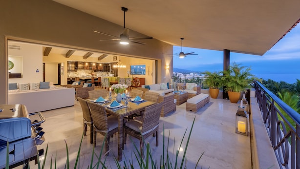 A spacious outdoor dining area with wicker furniture and a view of the city. - Ocean View Hacienda de Mita Penthouse, Premier Golf  (Punta de Mita)