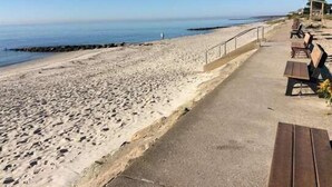 Une promenade en bord de mer, agrémentée de bancs et d’un espace de repos abrité.