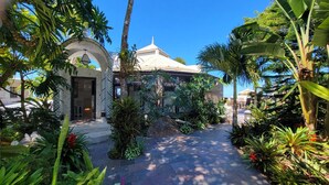 Um jardim tropical que leva a um edif ício com uma cúpula e uma entrada com azulejos.