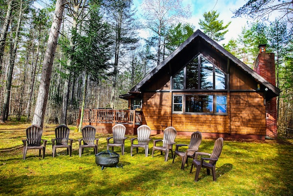 Escape to a serene cabin nestled in the forest, offering scenic views and a cozy porch area.