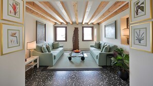 Een moderne woonkamer met twee groene banken, een salontafel en een decoratief middelpunt.