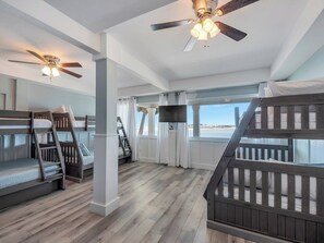 A room with bunk beds, a ceiling fan, and a view of the beach. - Navarre Beach Waterfront Home | Sleeps 22 | Gulf & Sound Views | Paradise Point (Navarre Beach)