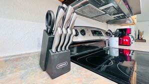 Eine Küche mit einem schwarzen Herd, einer Kaffeemaschine und einem Messerblock.