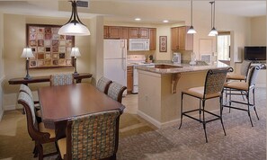 Enjoy cooking in the fully equipped kitchen with a central island, refrigerator, microwave, and stove.