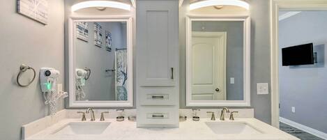 A bathroom with a double vanity, two sinks, and a large mirror.