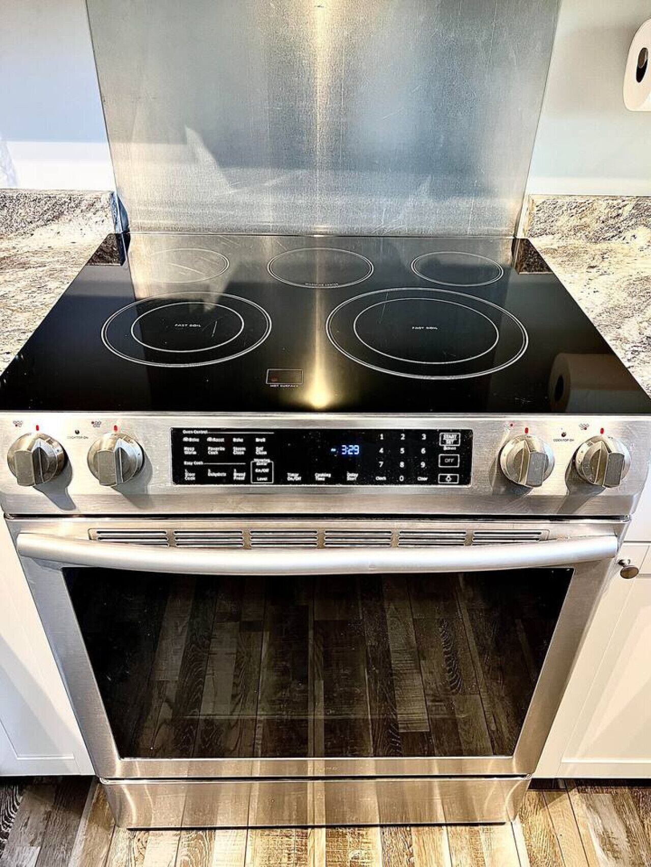 A stainless steel stove with four burners and a digital control panel.