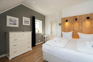 Un dormitorio moderno con una cama grande, un aparador y una pared de acento de madera.