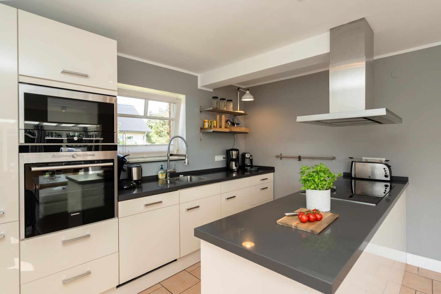 A modern kitchen with a built-in oven, a sink, and a toaster.