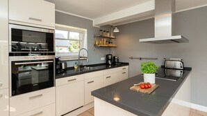 Una cocina moderna con horno integrado, un lavamanos y un tostador.