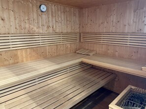 A sauna with wooden benches and a clock on the wall. - Min Hüs OG - Apartment close to the beach for 6 pers. with sauna, terrace, WLAN. Pets (Sylt)