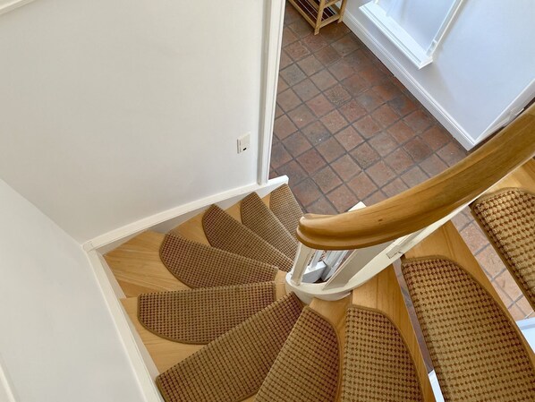 A staircase with wooden steps and a wooden handrail.