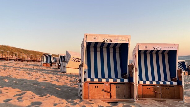 Strandkörbe mit den Nummern 2214 und 2213, vor einem Sandstrand und Dünen.