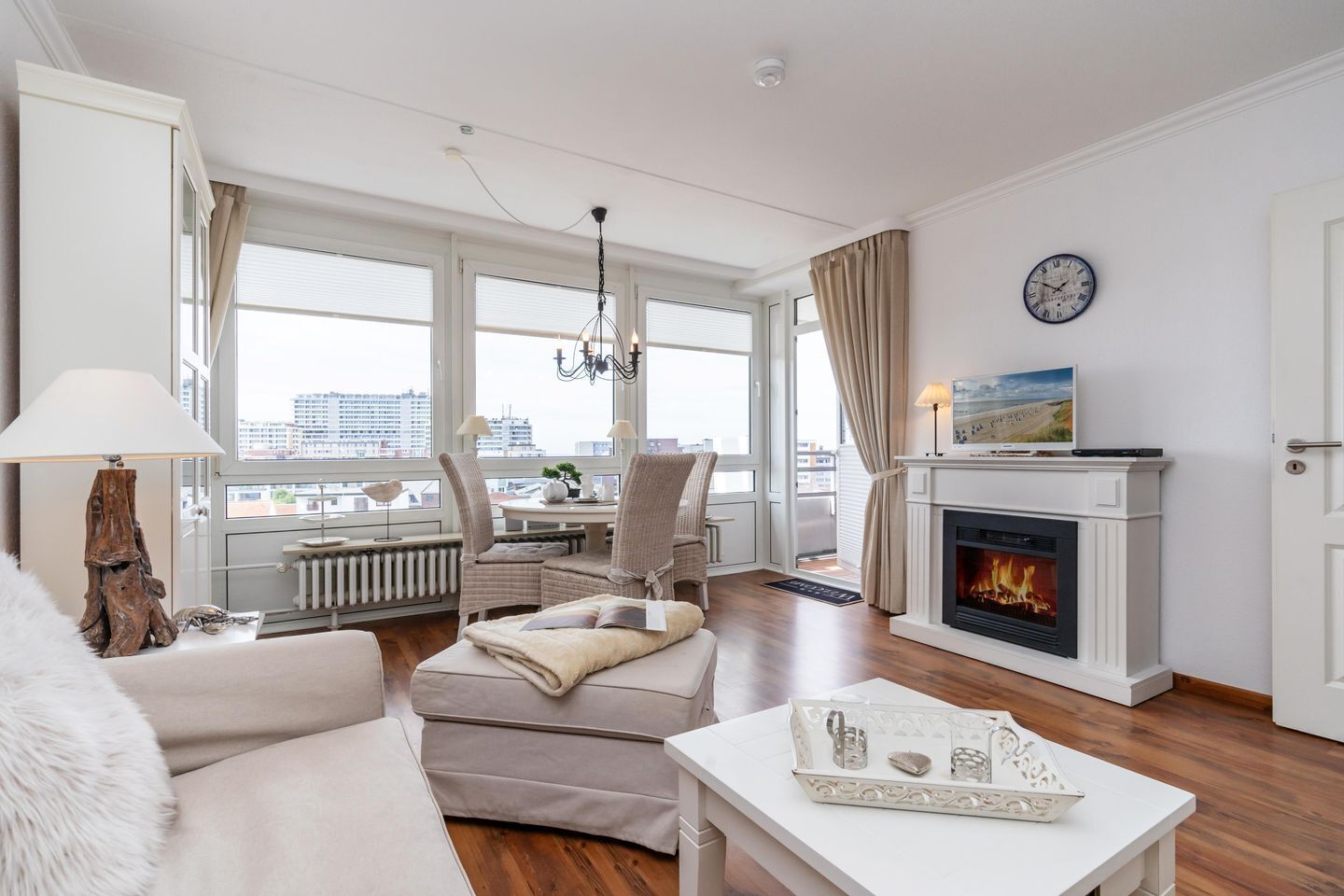 Ein modernes Wohnzimmer mit Kamin, Essbereich und Blick auf die Stadt.