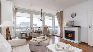 Ein modernes Wohnzimmer mit Kamin, Essbereich und Blick auf die Stadt.