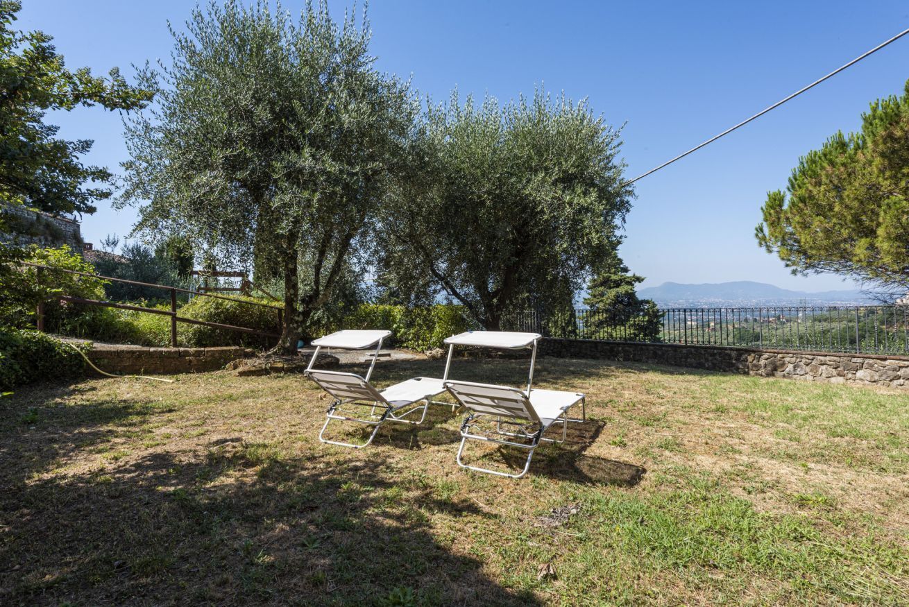 An outdoor area with metal chairs and a stone wall.