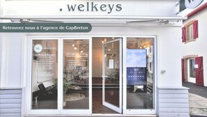 A storefront with a sign reading "welkeys" and a glass door entrance. - Villa de la Côte - Welkeys (Labenne)