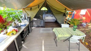 Une tente compacte équipée d’un coin cuisine, d’un lit et d’un espace repas.