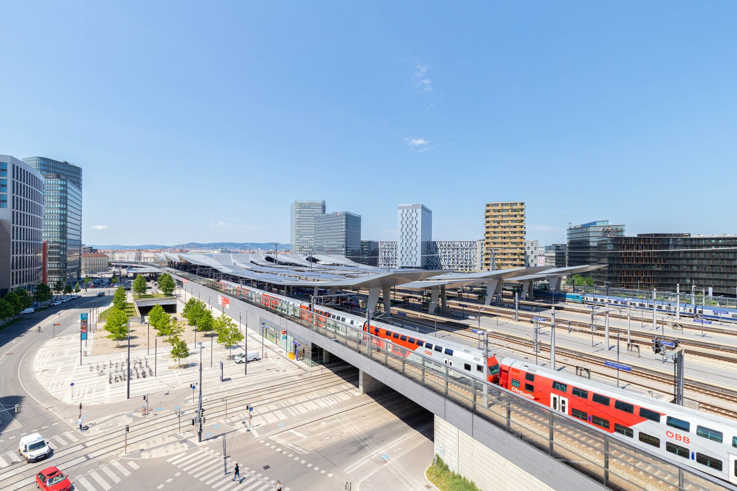 Een modern treinstation met meerdere sporen en een overdekte voetgangersbrug.