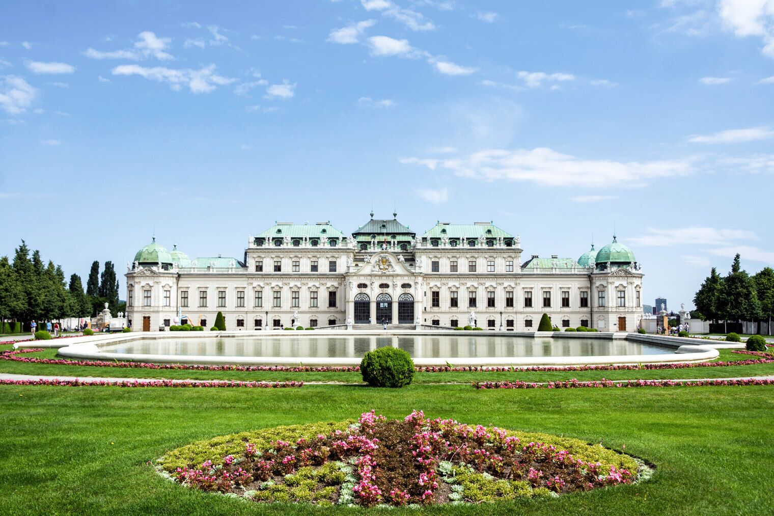 A large, ornate building with a symmetrical facade, a central courtyard, and a fountain.