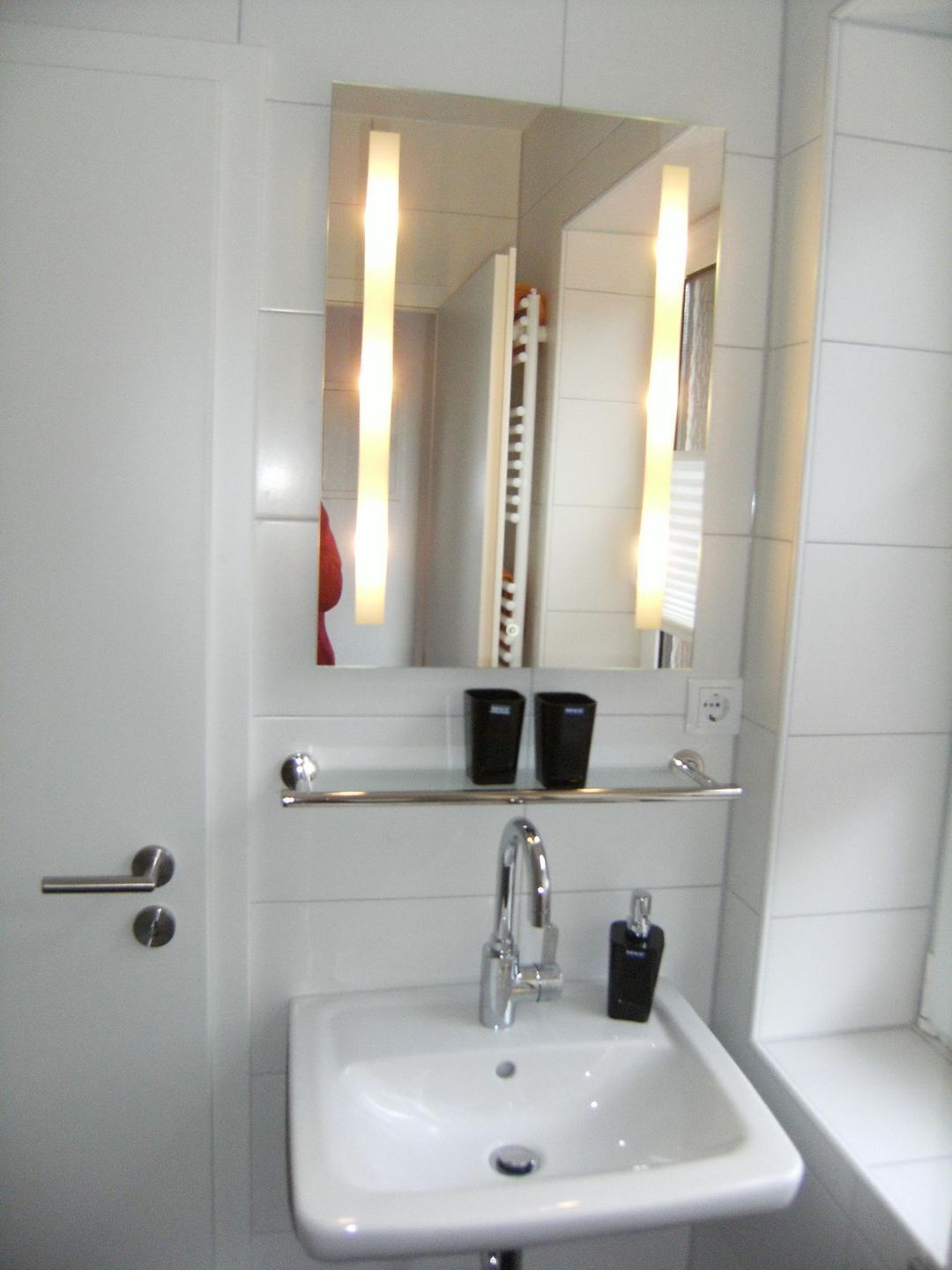 Ein Badezimmer mit Waschbecken, Spiegel und Handtuchhalter.