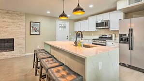A modern kitchen with a large island, stainless steel appliances, and pendant lighting. - Tucson Getaway w/ Private Pool & Gas Grill! (Tucson)