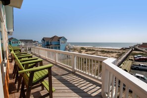 A wooden deck with green chairs, a white railing, and a view of the beach and ocean. - Semi-Oceanfront, Pool, Theater, Elevator, Stunning Ocean Views (Rodanthe)