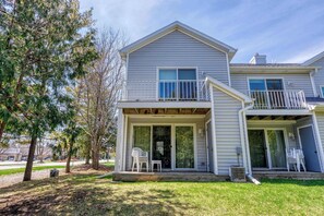 A two-story house with a covered front porch, a balcony, and a sliding glass door. - Central Fish Creek - Hilltop Hideaway Condo (Fish Creek)
