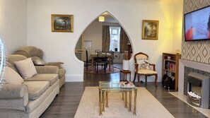 Un salon comprenant un canapé, une table basse, une cheminée et un téléviseur.