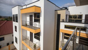 A multi-story building with balconies and a sign indicating it is an apartment complex.