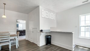 A modern kitchen with a dining area, wooden flooring, and a built-in bench. - Comfortable 3 - Bedroom Norfolk Stay  – Minutes from Bases and ODU (Norfolk)