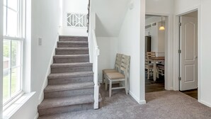 A staircase with a carpeted floor leading to a dining area with a table and chairs. - Comfortable 3 - Bedroom Norfolk Stay  – Minutes from Bases and ODU (Norfolk)