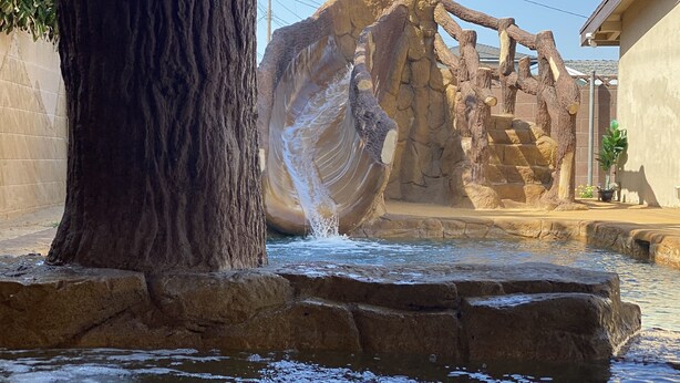A rock formation with a water feature in a landscaped area. - CLOSE TO DISNEYLAND & CONVENTION CENTER  (Anaheim)